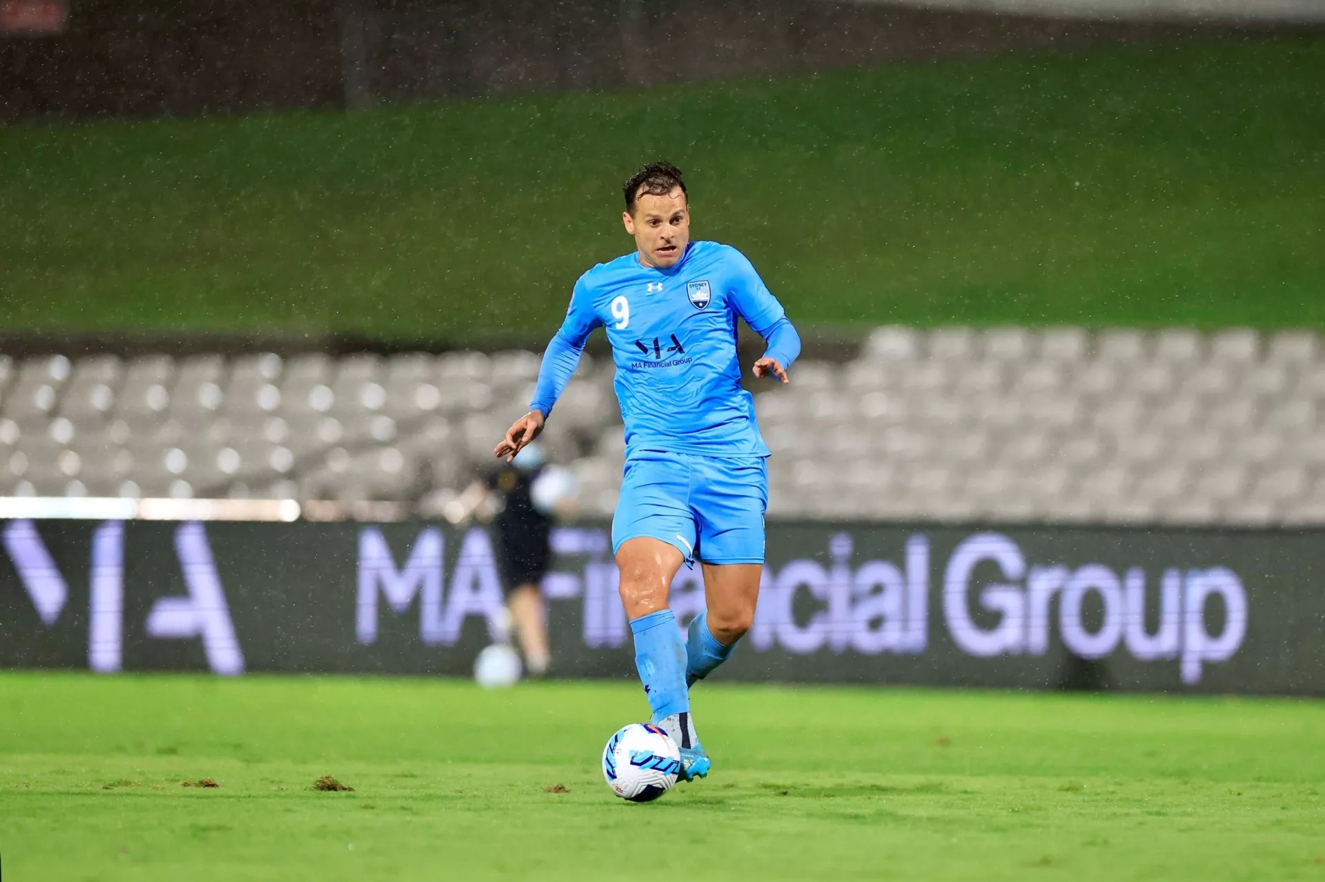Male Sydney FC soccer player dribbling a ball