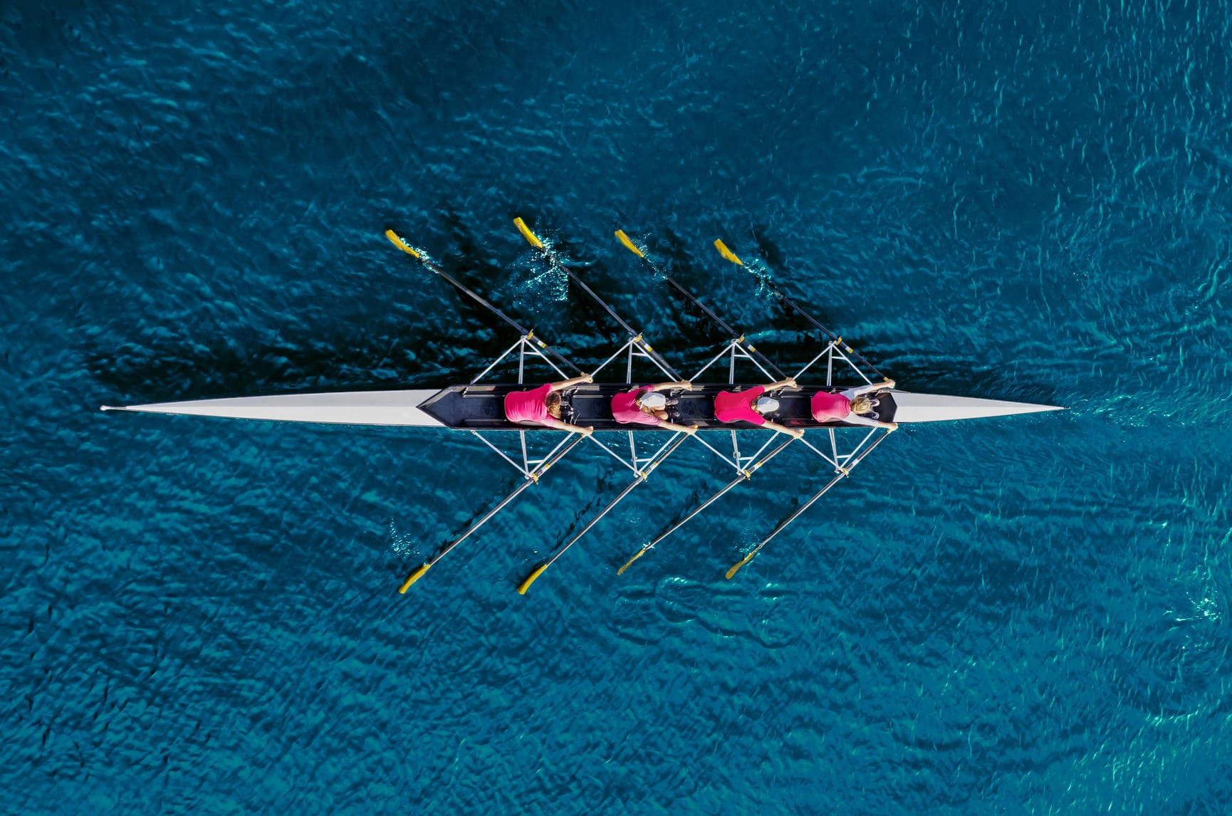 Overhead view of a quad of rowers wearing red zooties