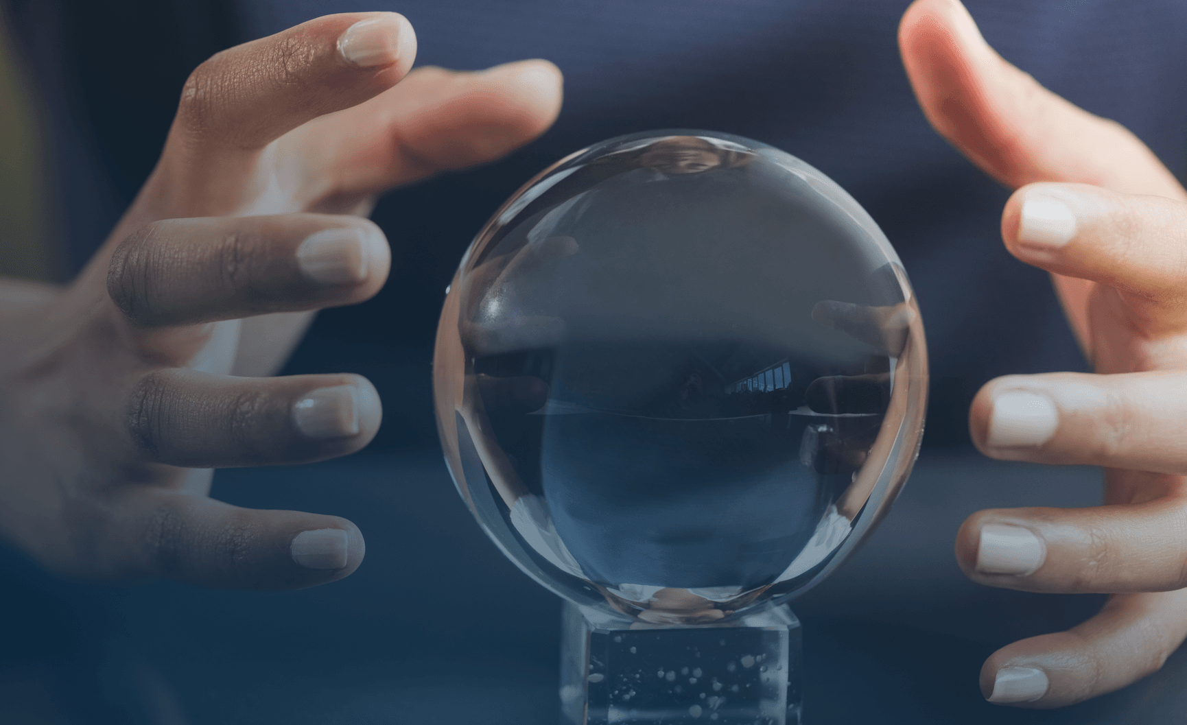 Hands hovering around a crystal ball