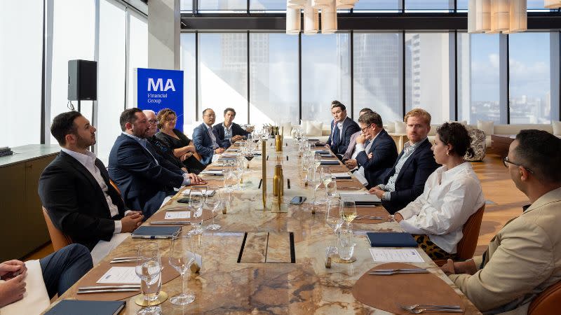 Large group of people sitting around a boardroom table